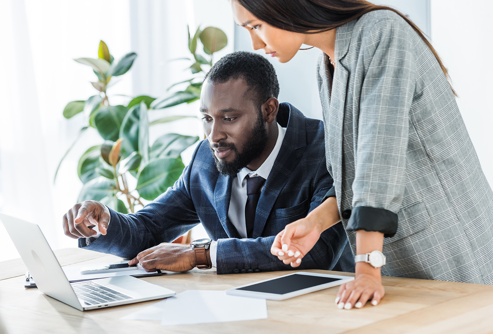 Two coworkers discuss nonprofit AI solutions while looking at a laptop